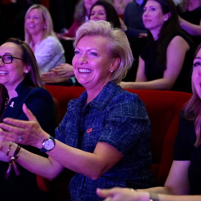Women in estate agency smiling and clapping at an industry event celebrating professional achievement and community